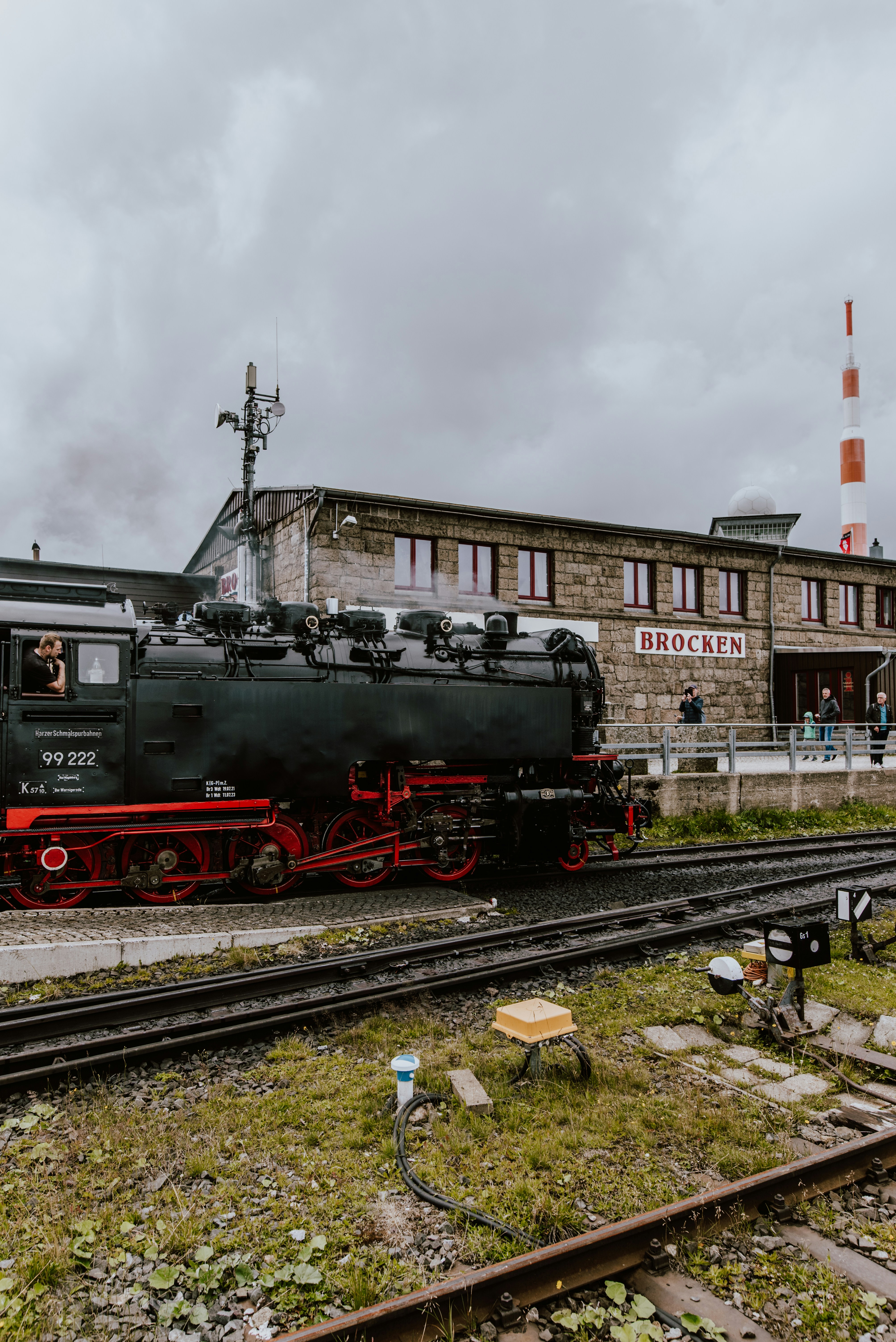 a black train engine sitting on the tracks in front of a building