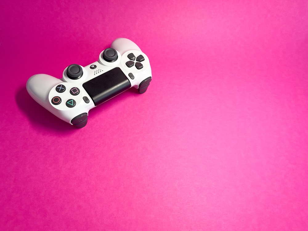 Un controlador de videojuegos sobre un fondo rosa