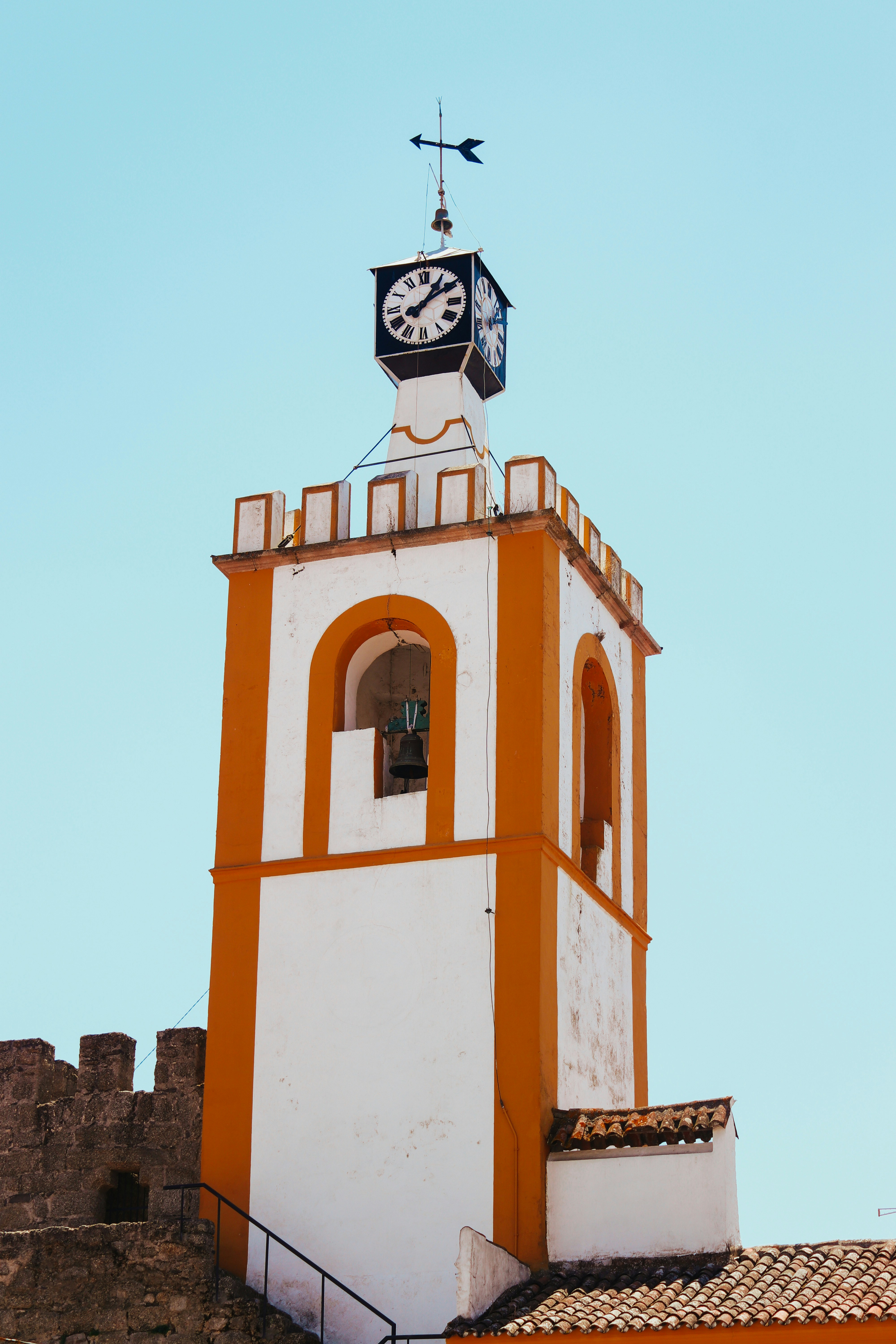 a white and orange tower with a clock on top