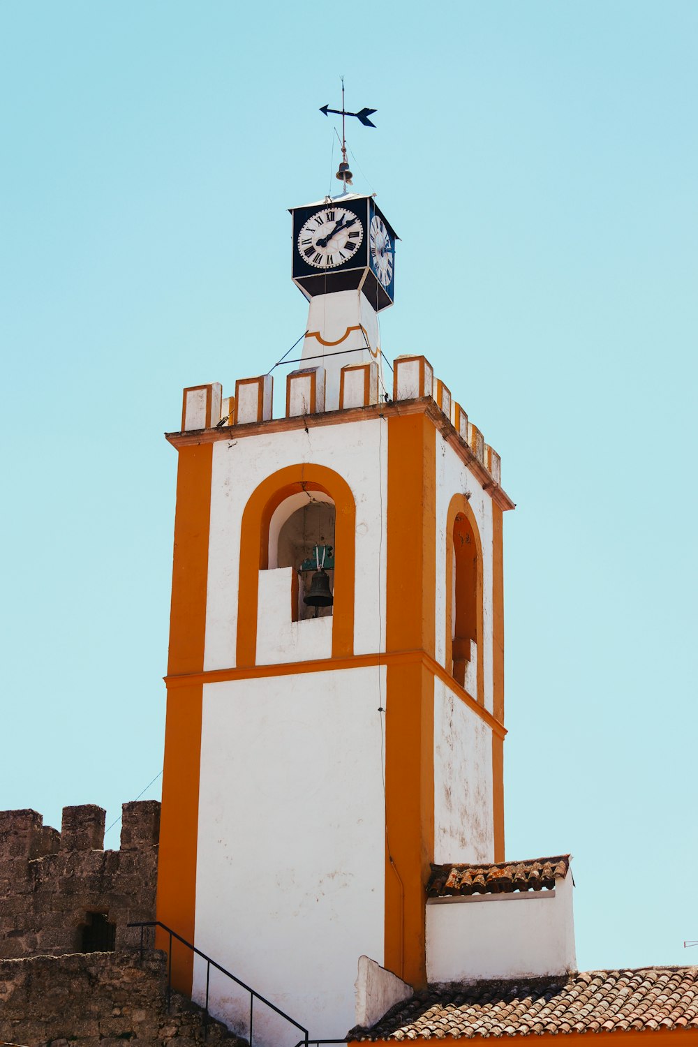 a white and orange tower with a clock on top