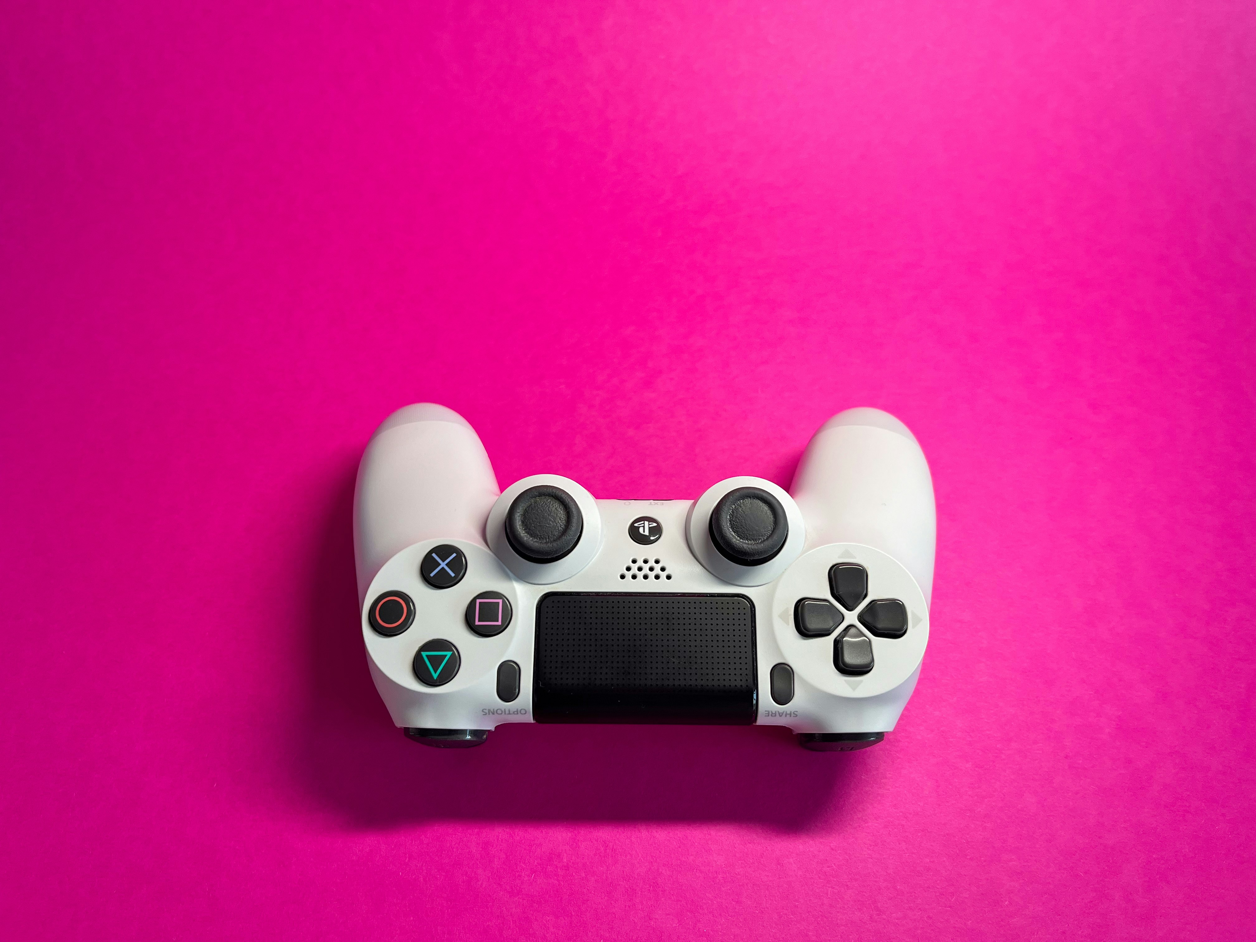 a video game controller on a pink background