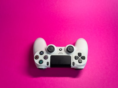 a video game controller on a pink background