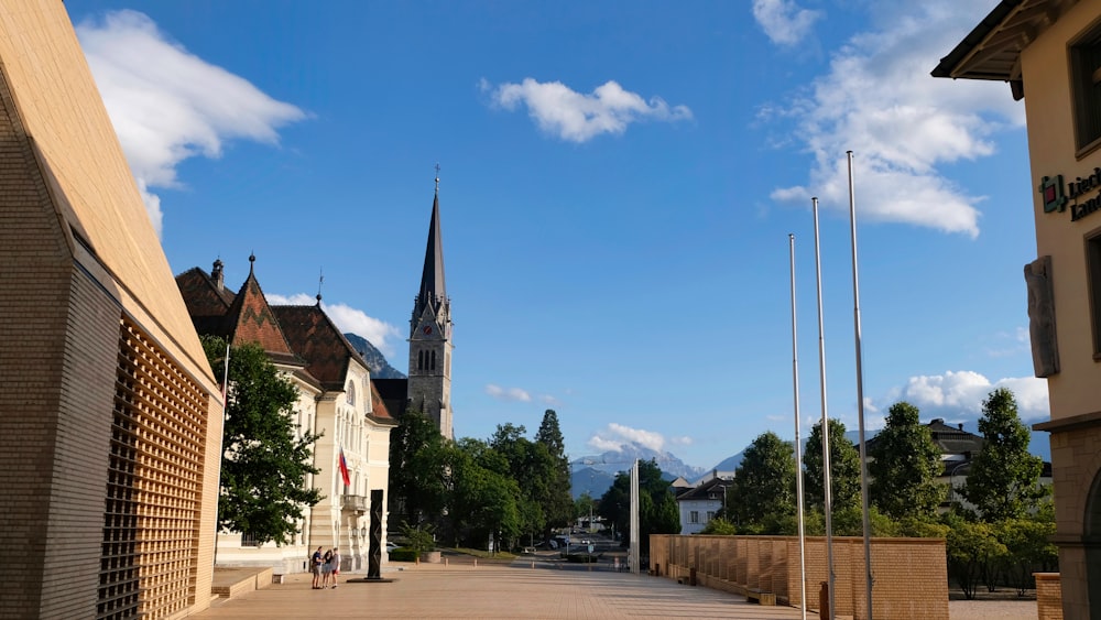 a city street with a church steeple in the background