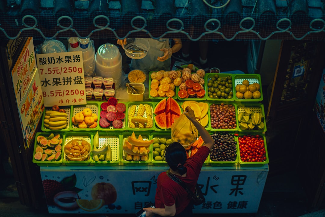 a person standing in front of a fruit stand,