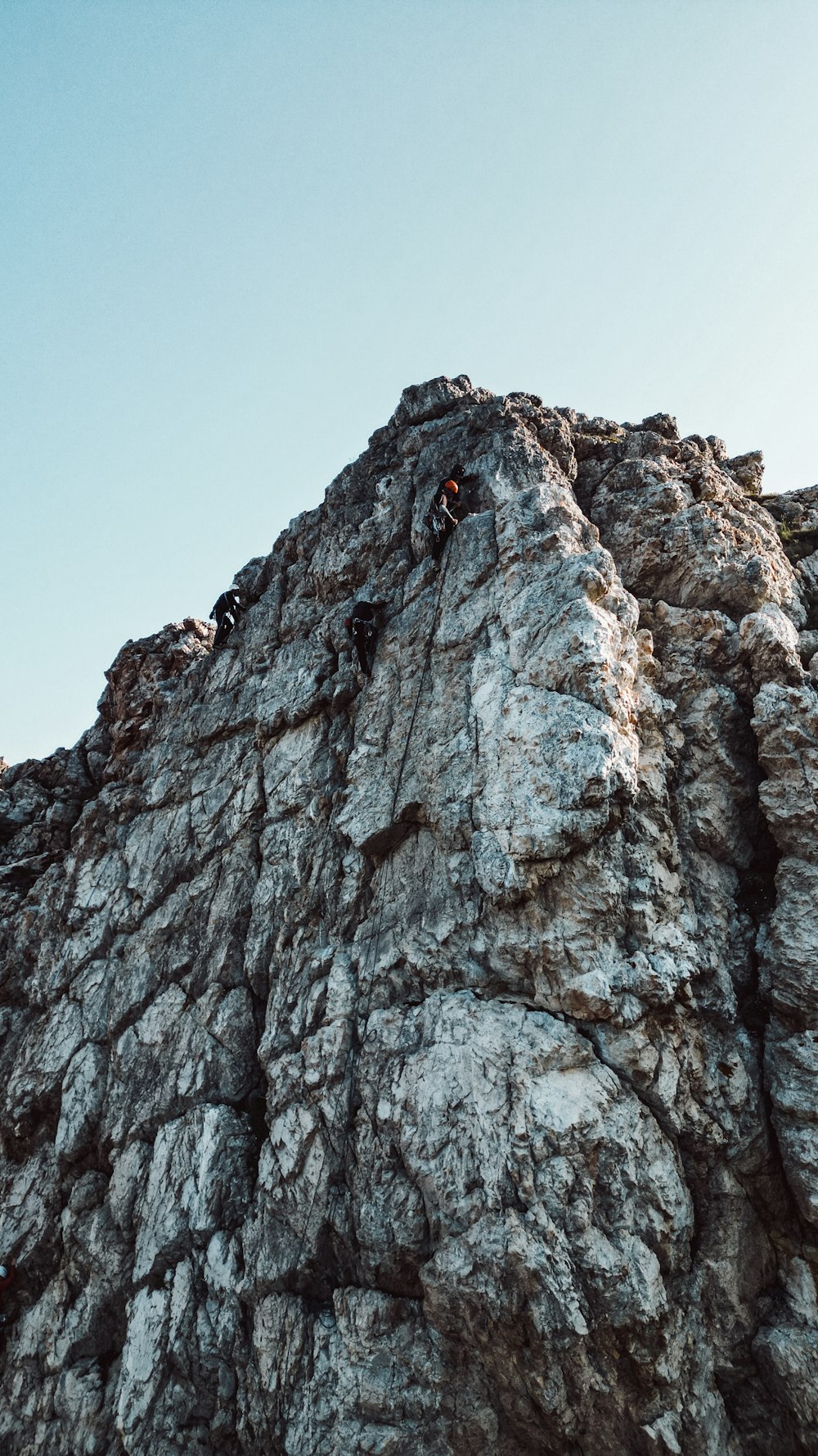 a person climbing up the side of a mountain
