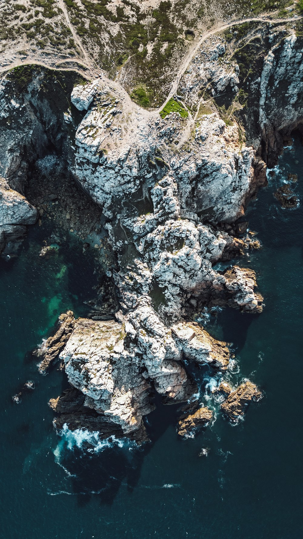 an aerial view of a rock formation in the ocean