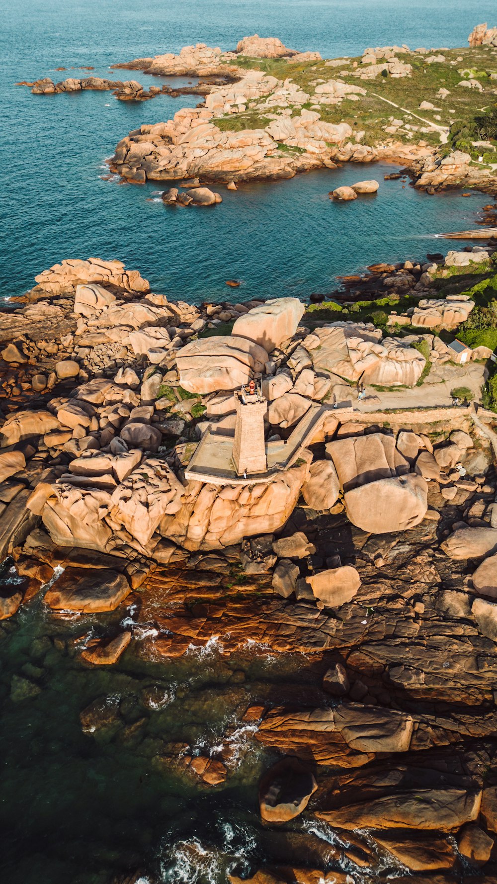 an aerial view of a rocky coastline with a body of water