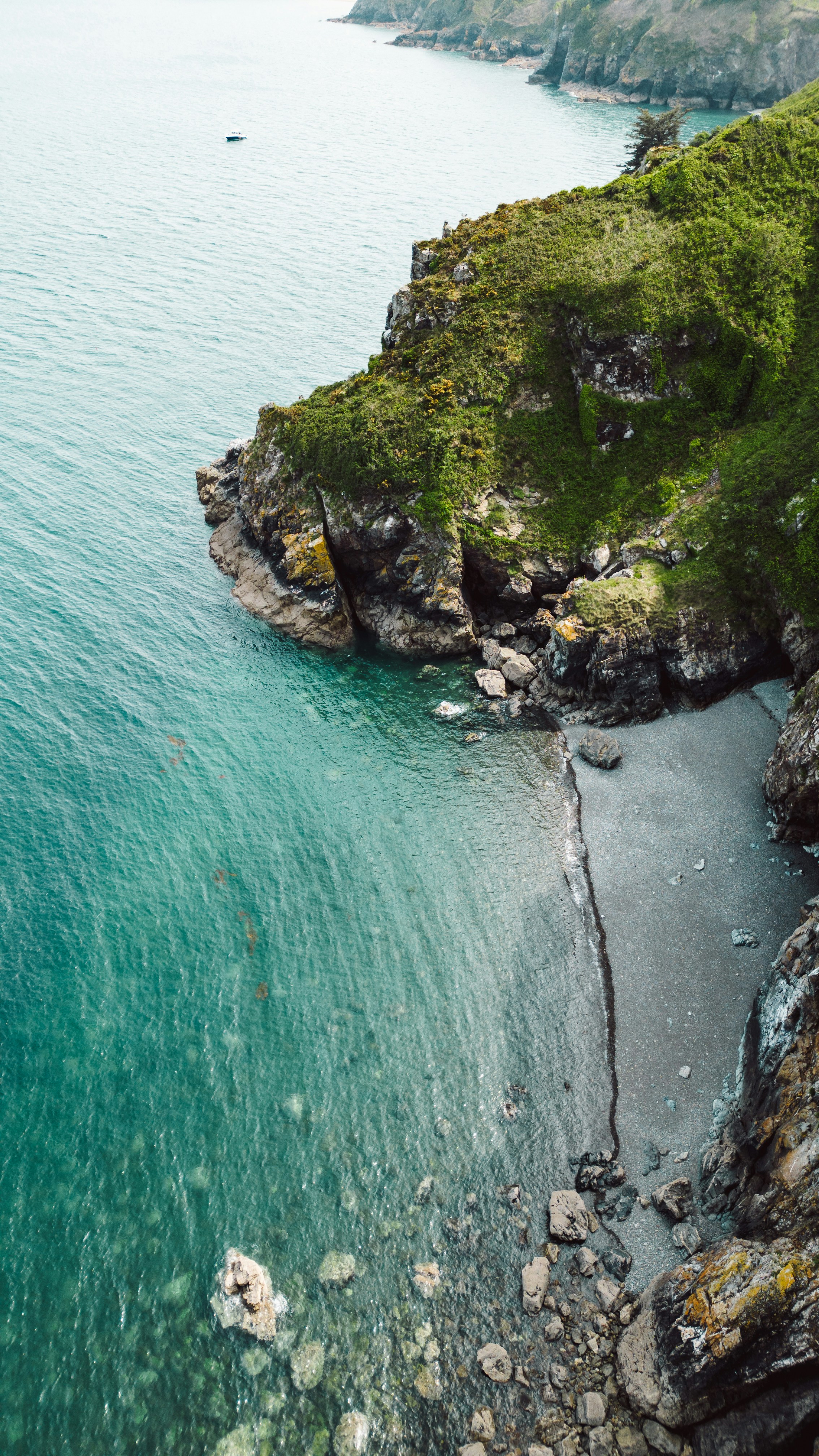 un cuerpo de agua rodeado por una exuberante ladera verde