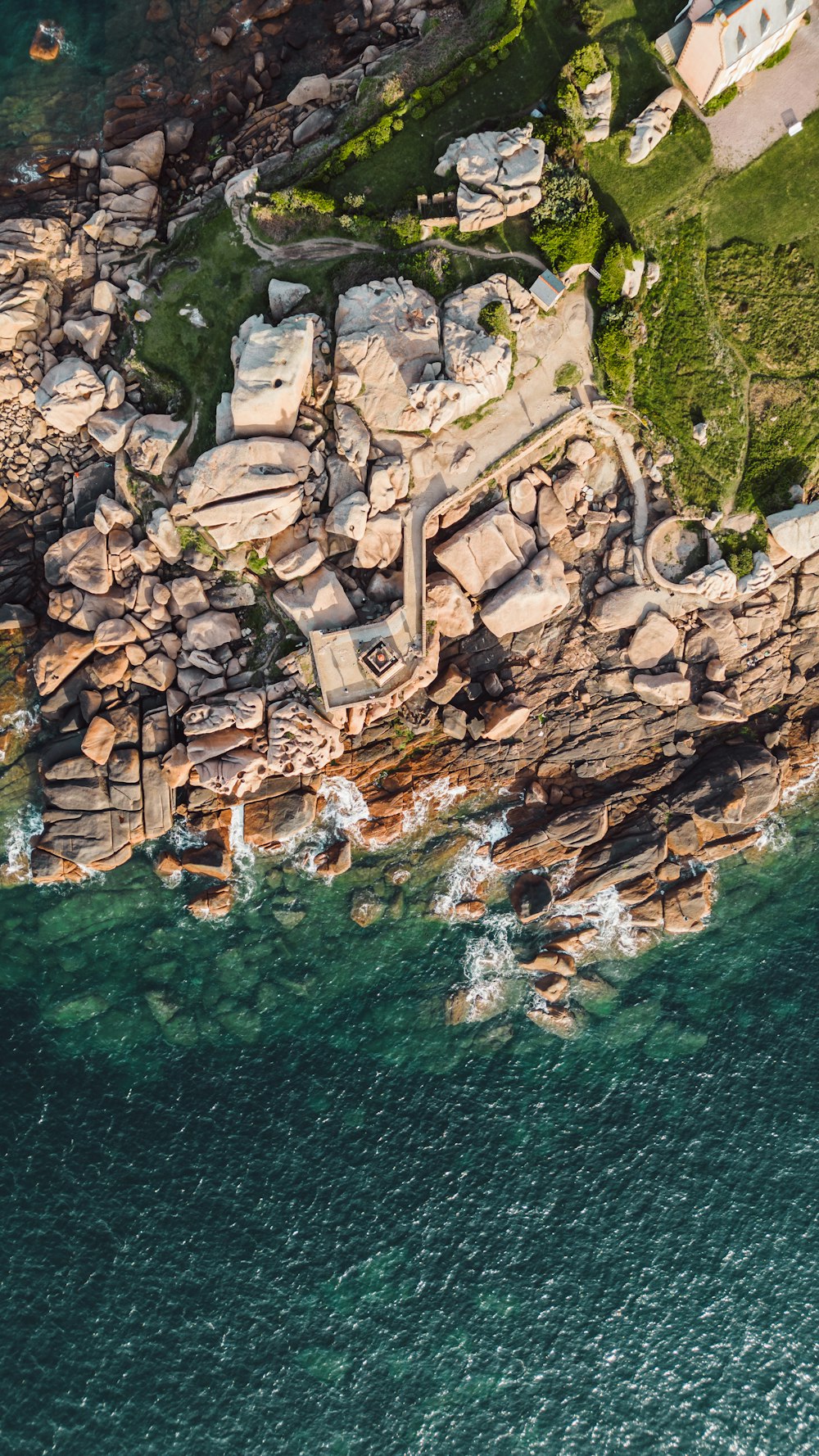 uma vista aérea de uma grande formação rochosa perto do oceano