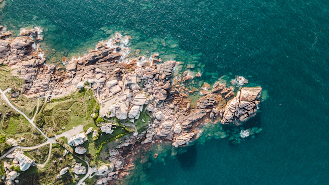 an aerial view of a rocky coastline and a body of water