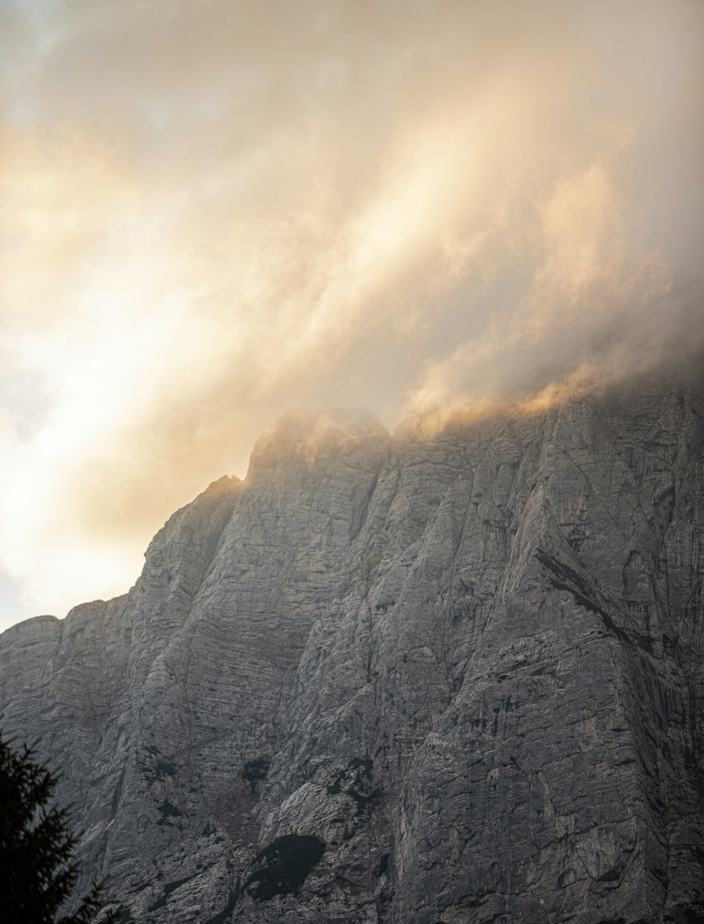 a very tall mountain with some clouds in the sky