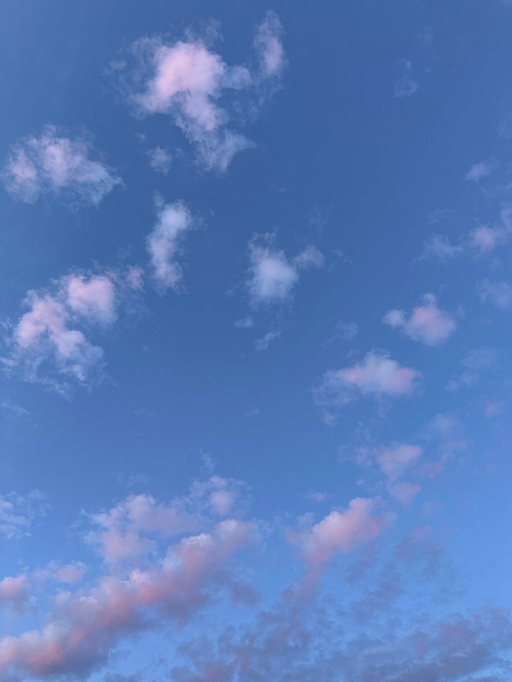 a plane flying through a blue sky with clouds