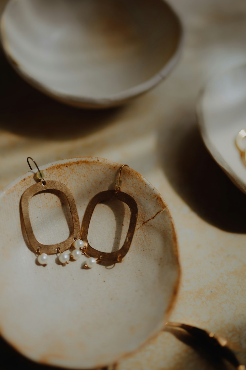 a pair of earrings sitting on top of a plate