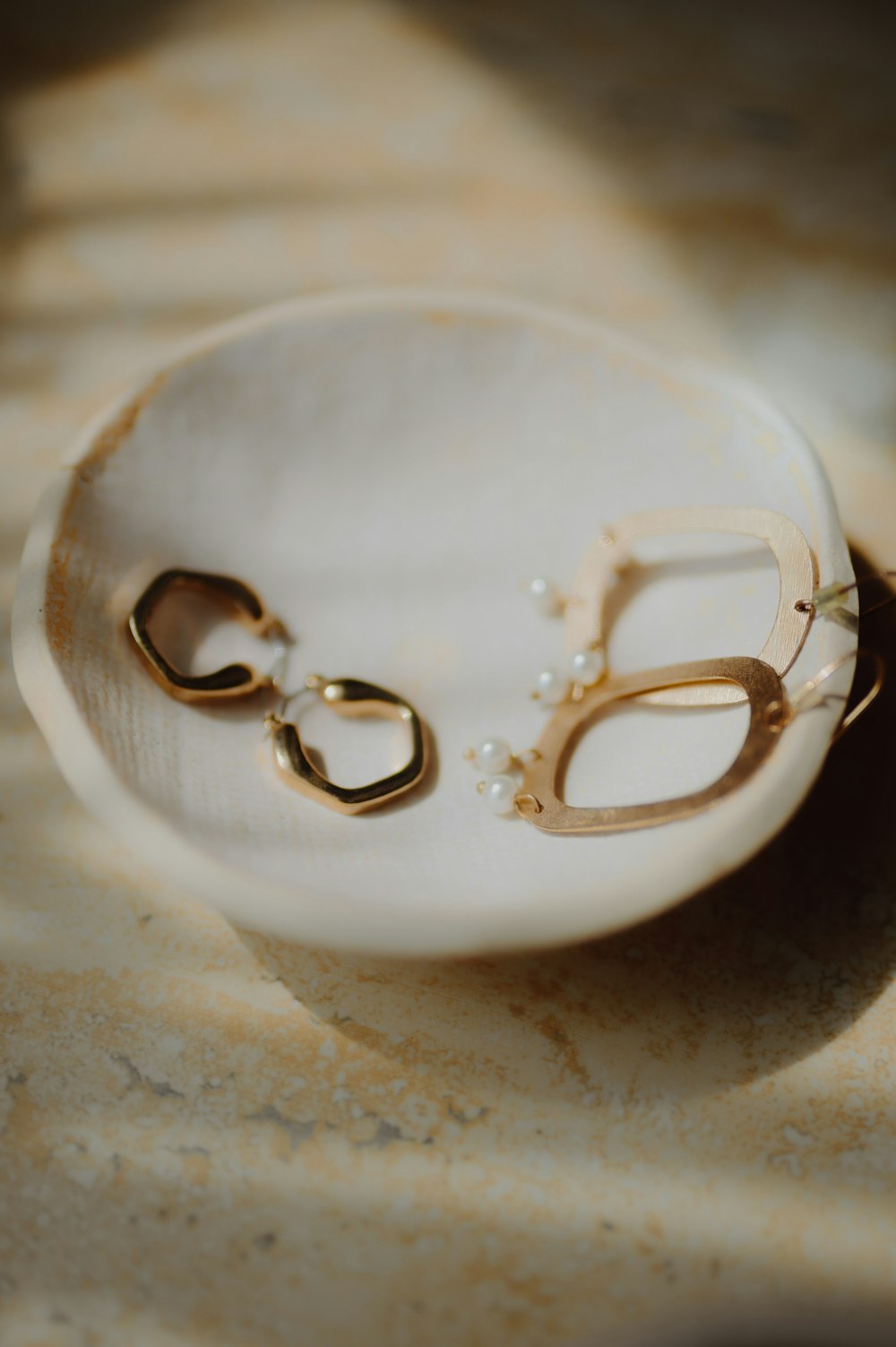 Une paire de ciseaux plaqués or repose sur une surface en marbre