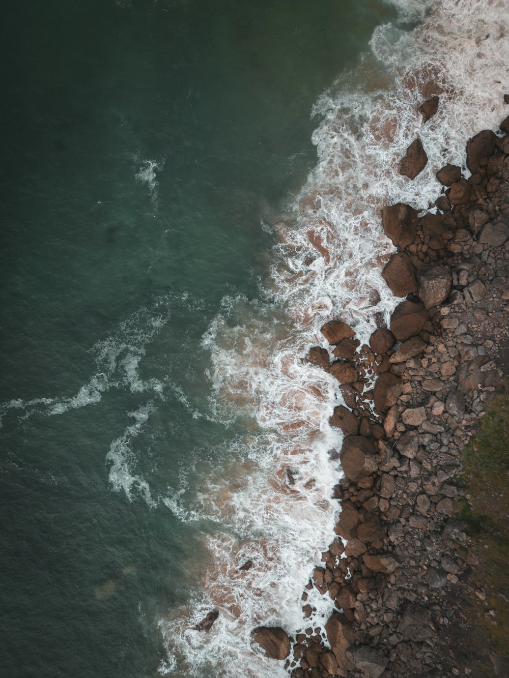 a bird's eye view of the ocean and rocks