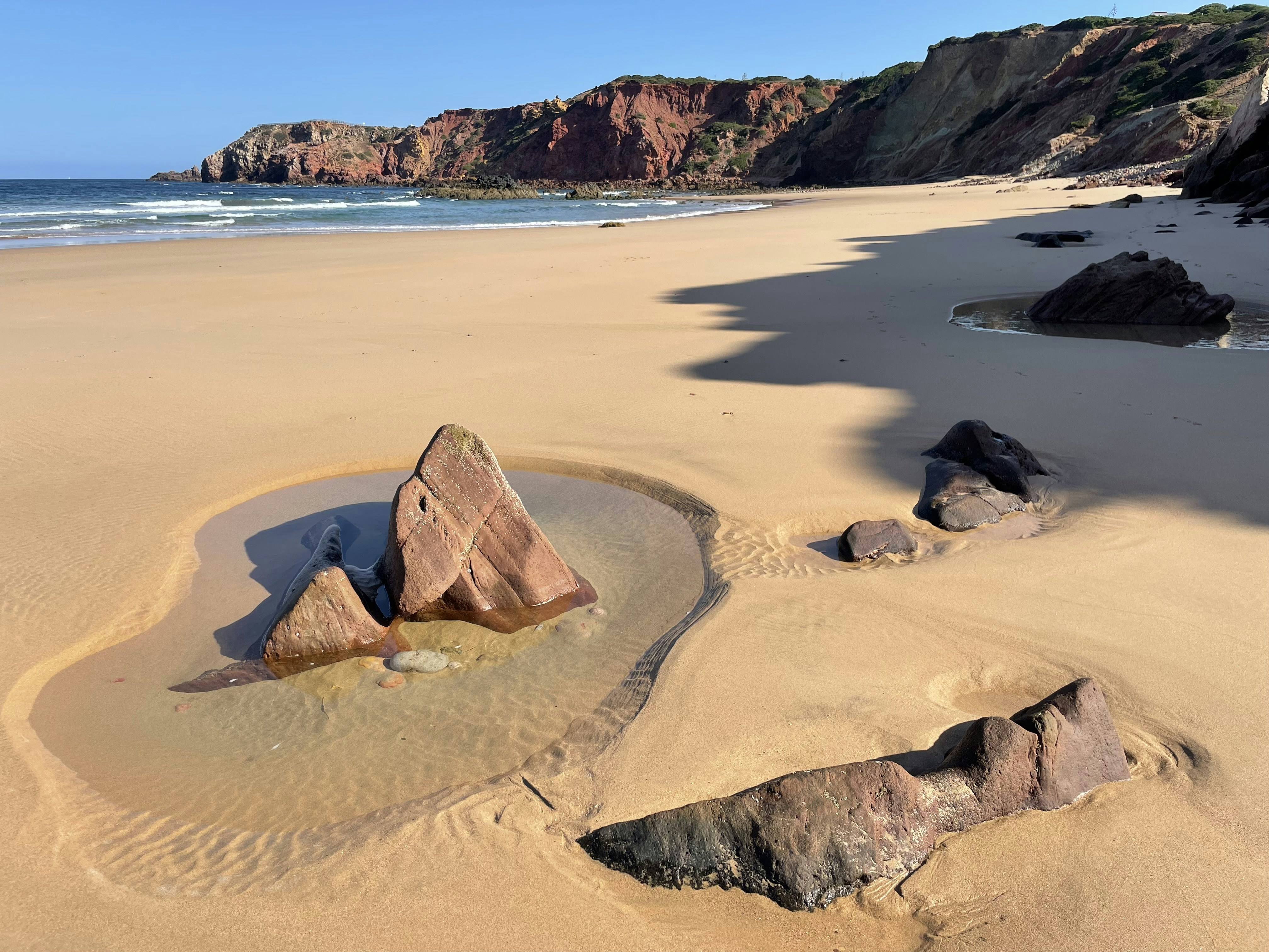 a sandy beach with rocks in the sand