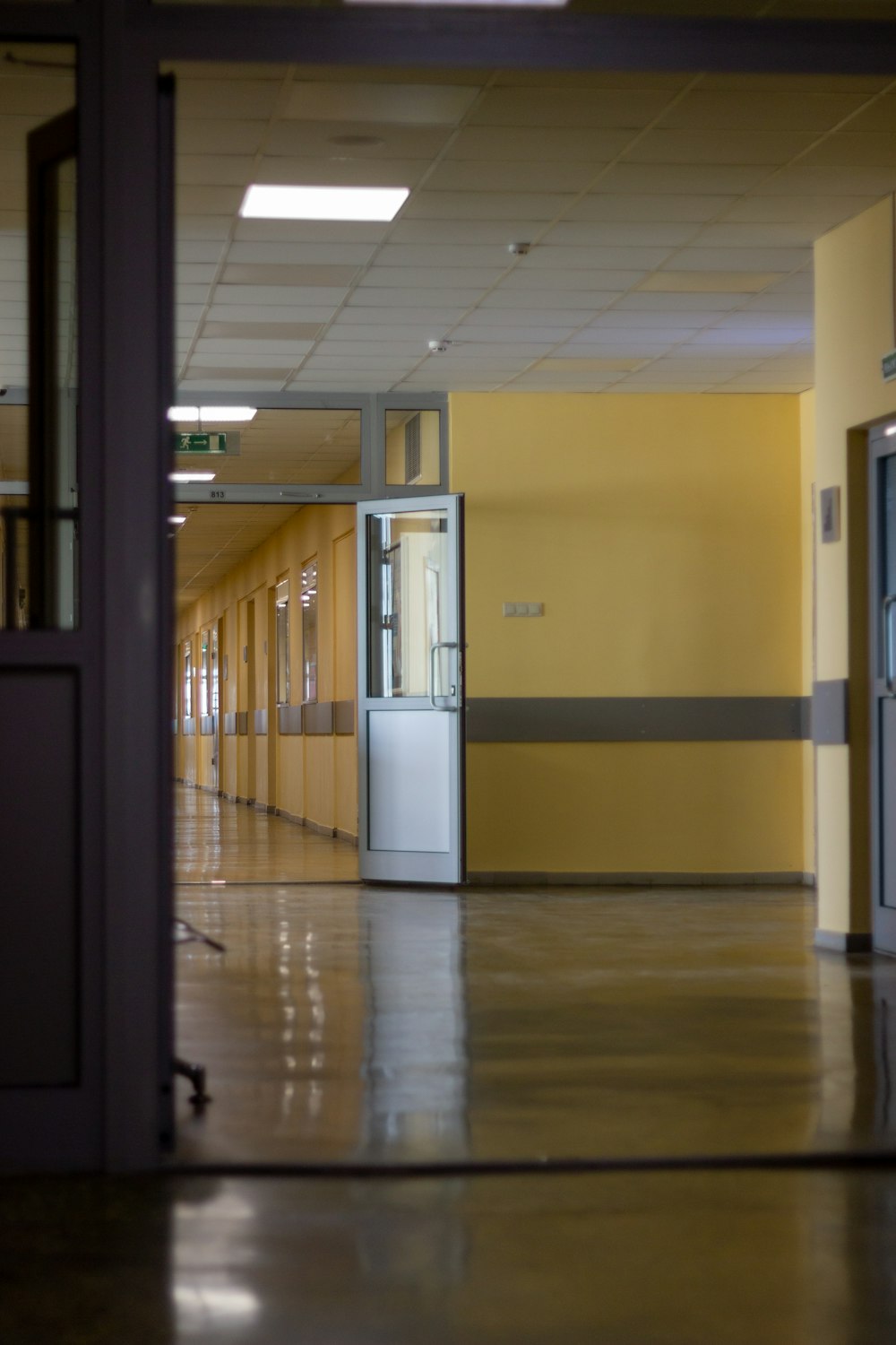 an empty hallway with yellow walls and doors
