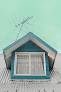 a blue house with a white window and a blue roof