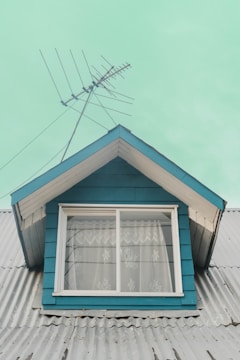 a blue house with a white window and a blue roof