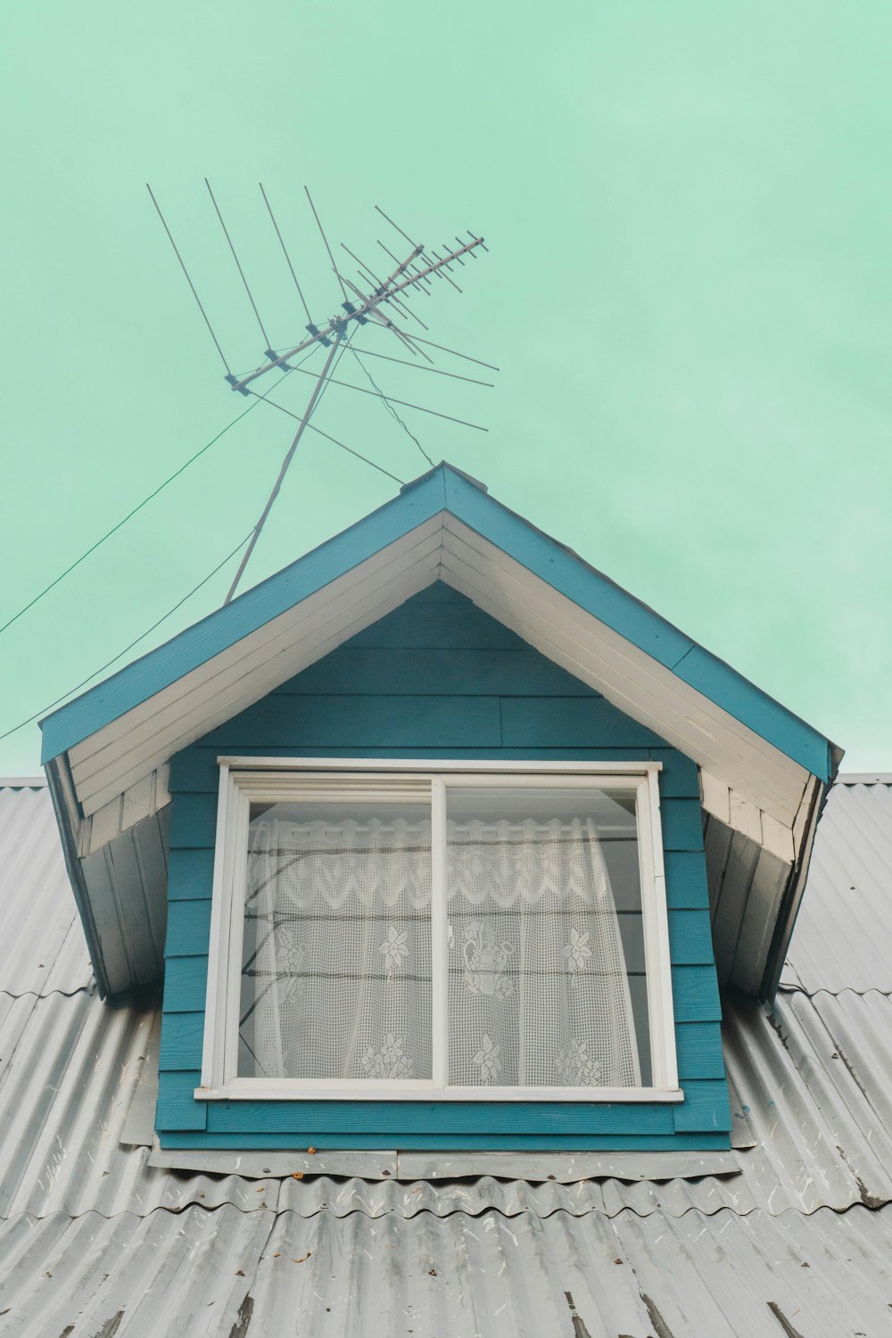 a blue house with a white window and a blue roof