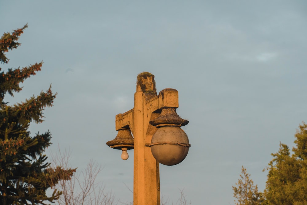 a large stone cross with bells on top of it