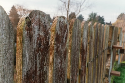 Photo of a technician repairing a wooden fence panel outdoors.