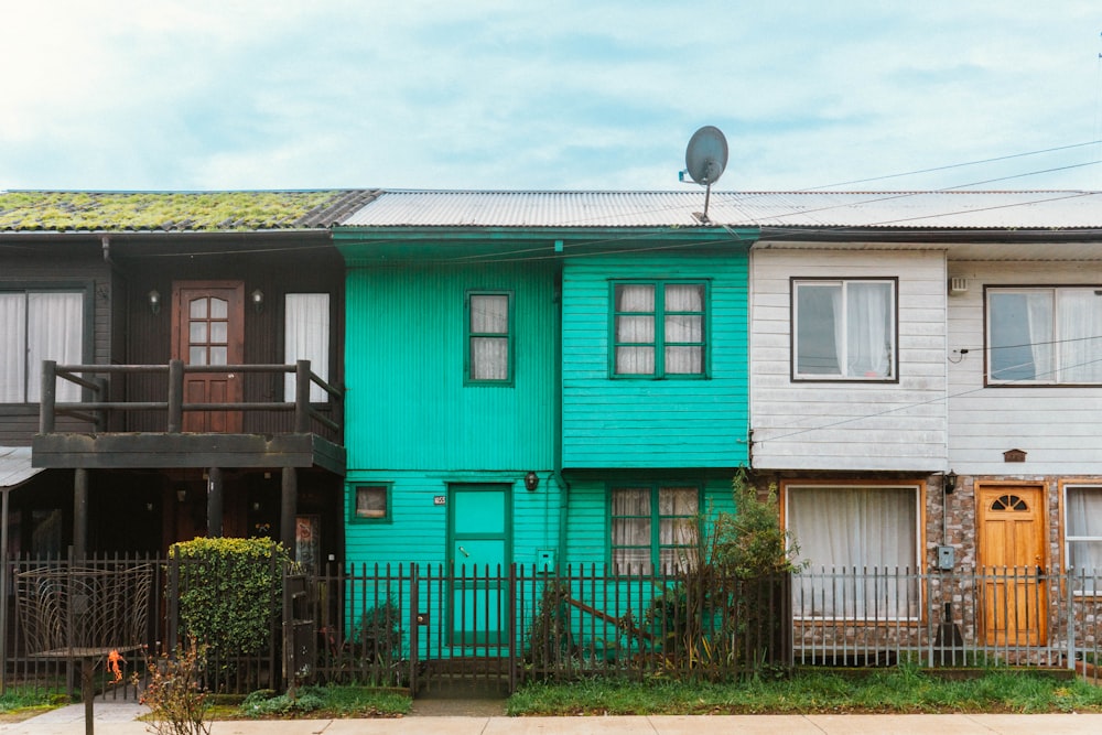 a row of multi - colored houses with a green roof