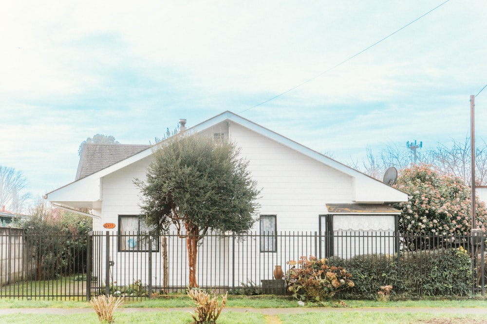 a white house with a black fence in front of it