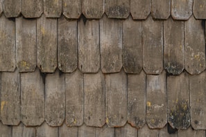 Before and after shots showing a repaired rustic shingle rooftop