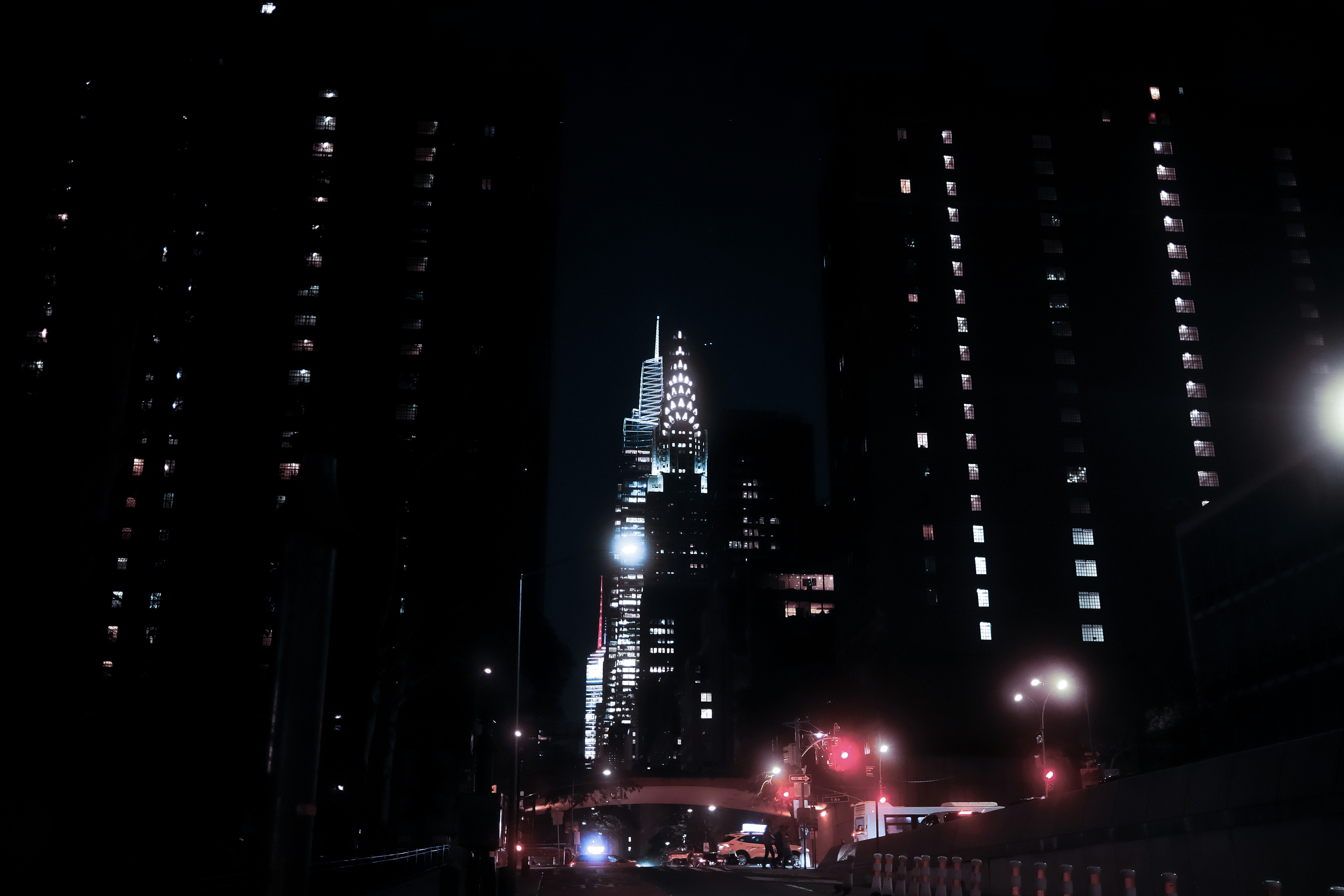 A city street at night with tall buildings photo – Free Summer Image on ...