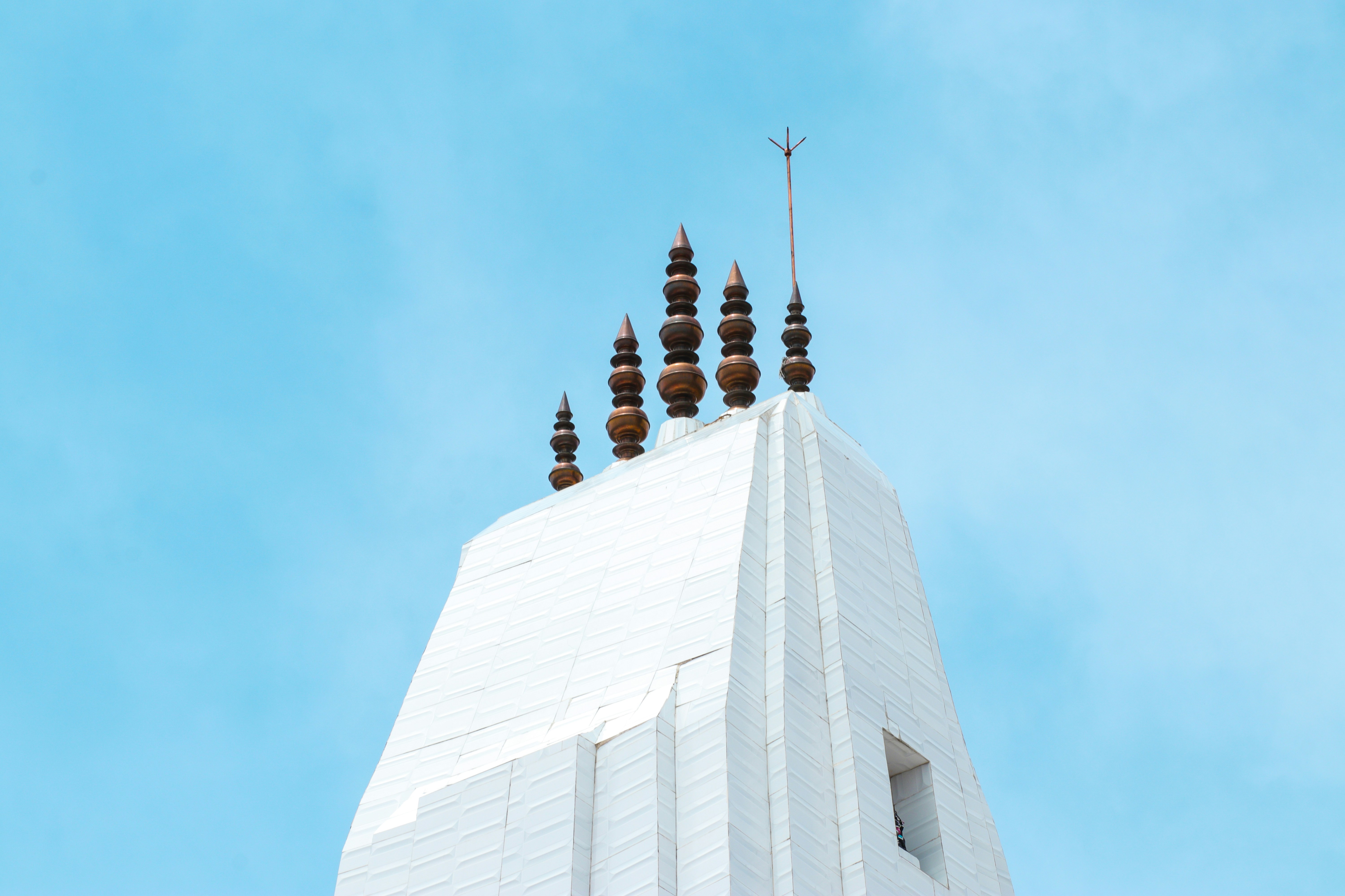 a tall white building with a clock on the top of it