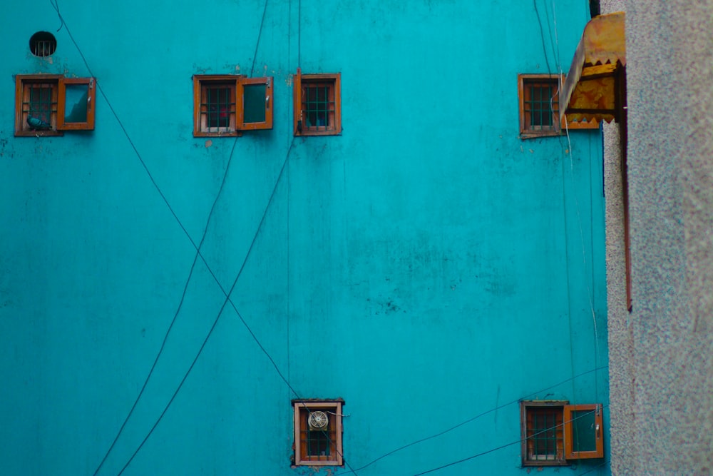 a blue building with several windows and wires