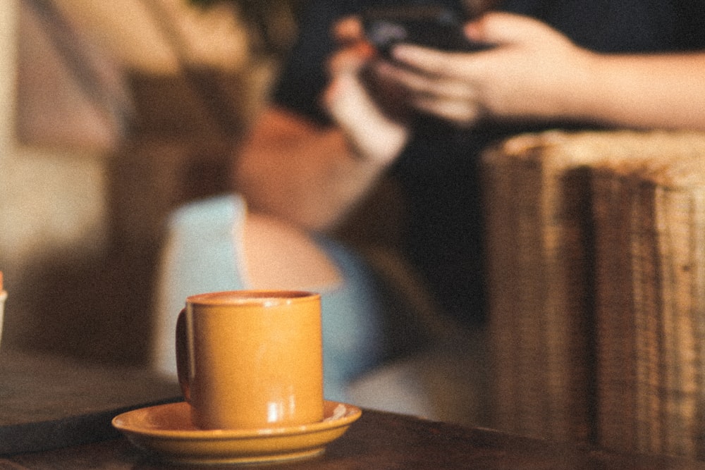 a cup of coffee and a cell phone on a table