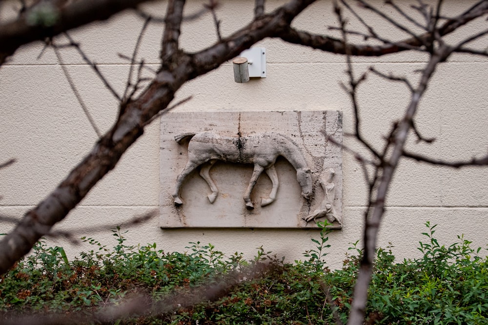 a sculpture of a horse on the side of a building
