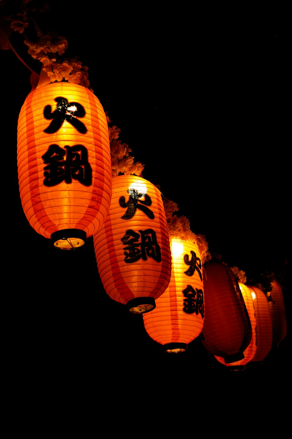 a group of chinese lanterns lit up in the dark