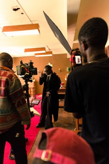 A film set with a director and crew coordinating a scene under professional lighting.