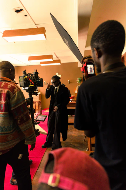 A cinematic shot of a film crew working on a set with cameras and lights.