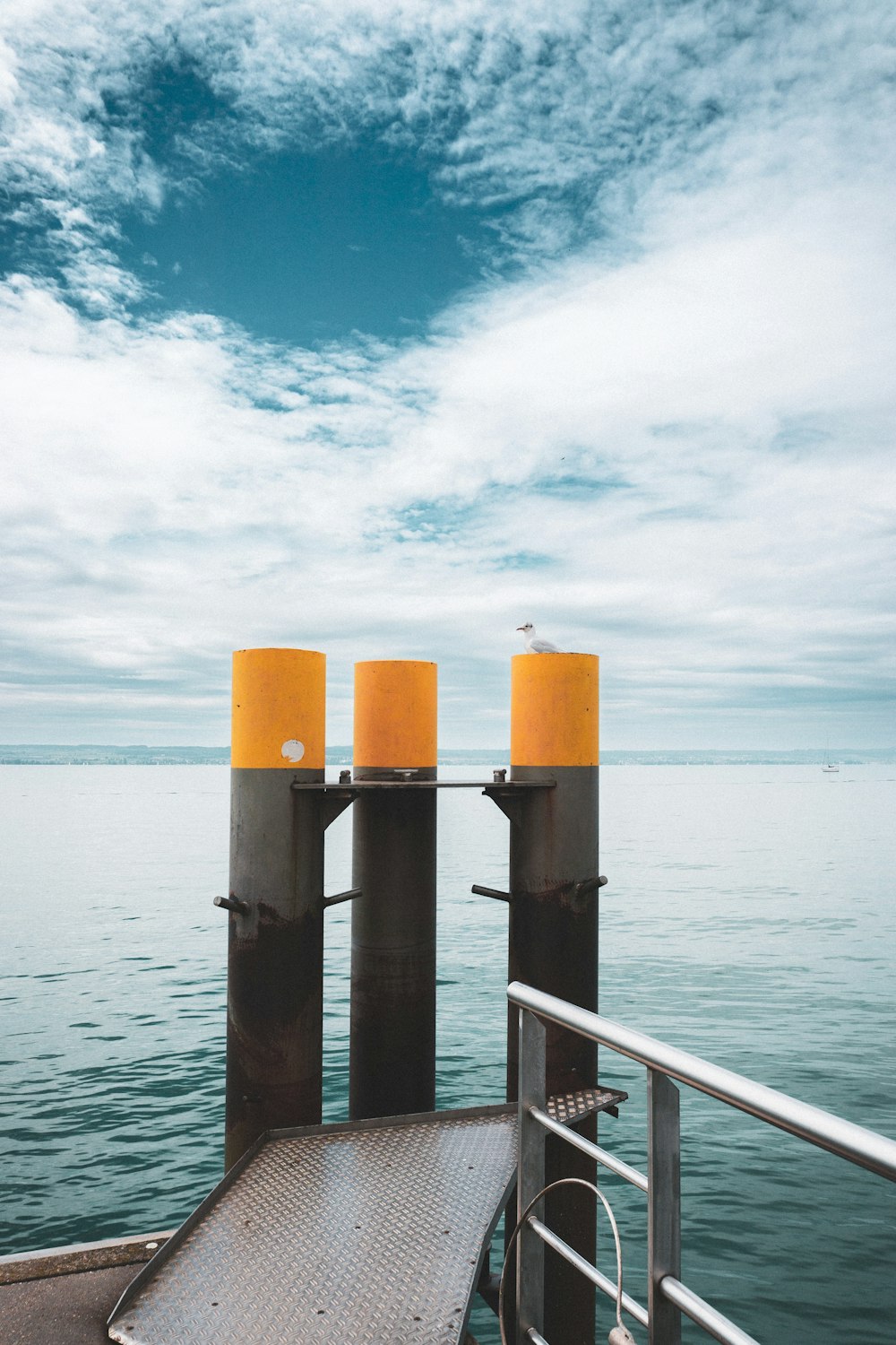 a dock with three yellow candles sitting on top of it