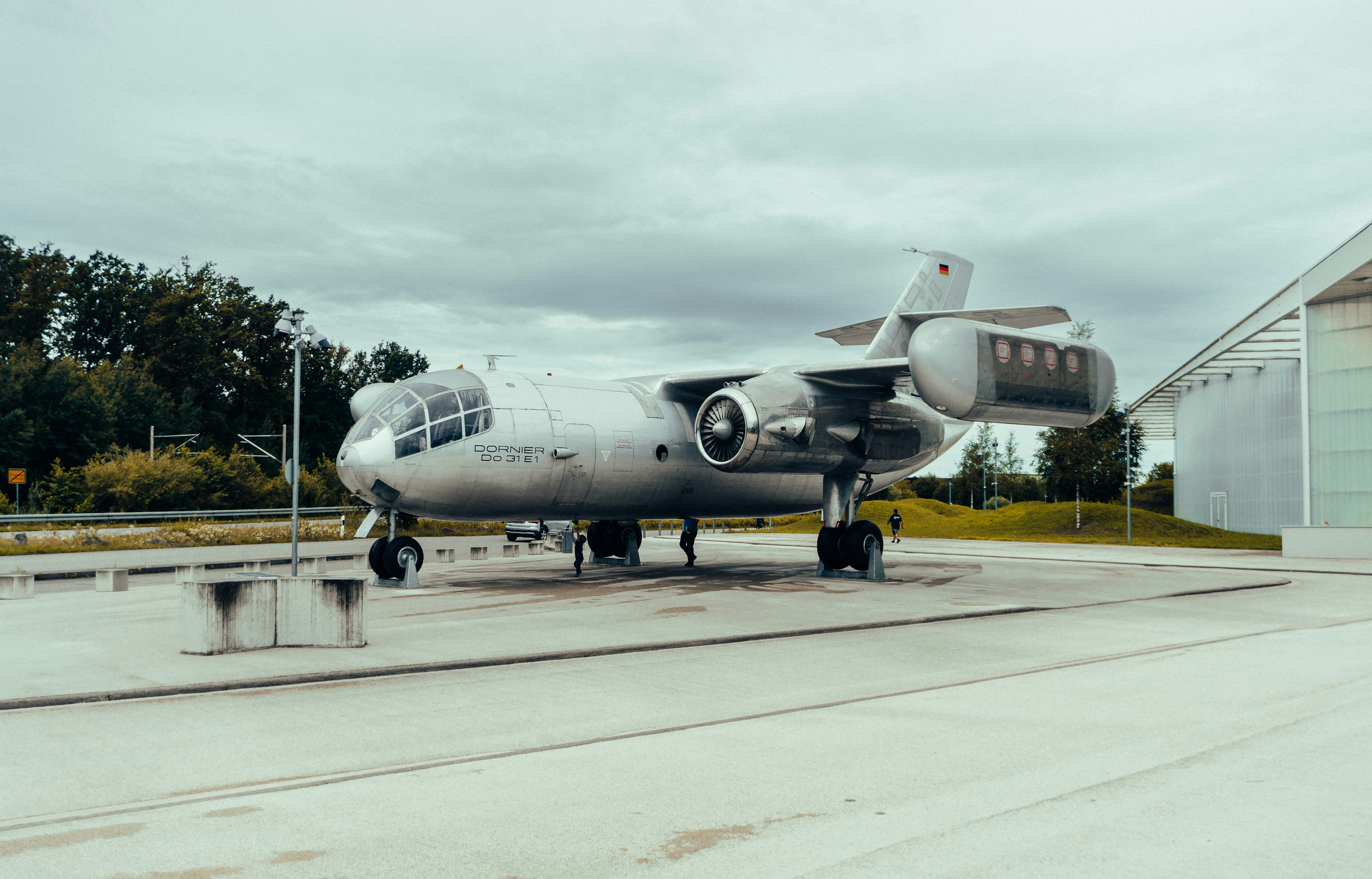 a silver airplane sitting on top of a runway, 
