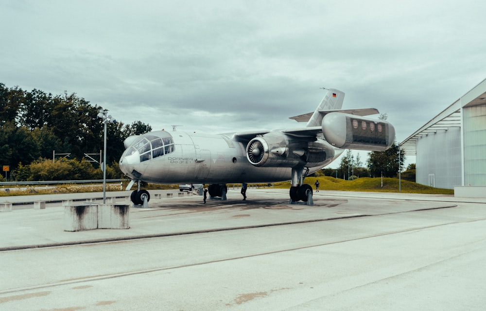 a silver airplane sitting on top of a runway