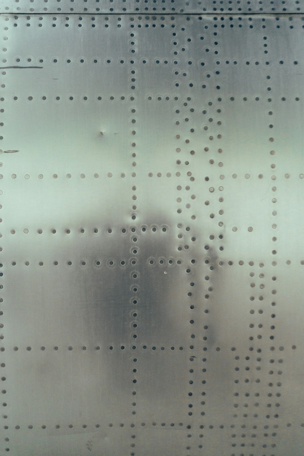 a close up of a metal surface with holes