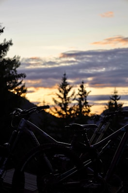 A sunset over a bike path with e-bikes in silhouette.