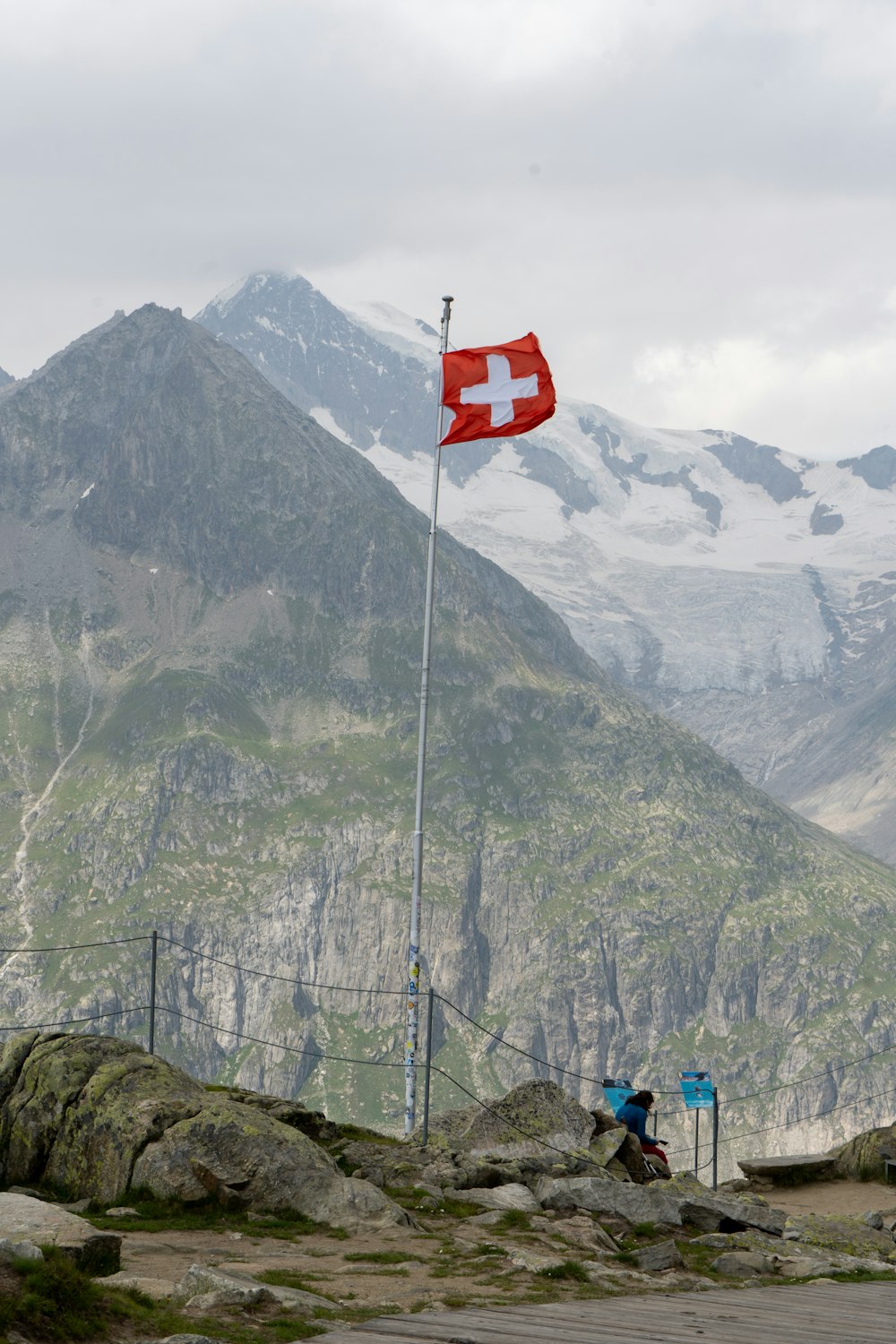 a red and white flag on top of a mountain