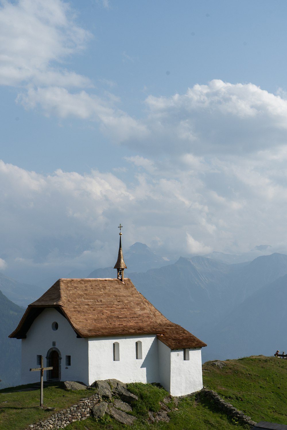 Una chiesa bianca con un tetto marrone sulla cima di una collina