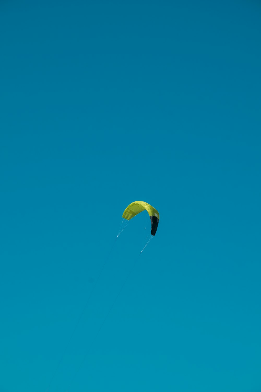 a kite is flying high in the blue sky