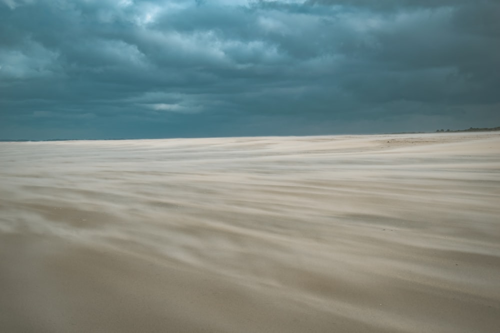 Une plage de sable sous un ciel nuageux