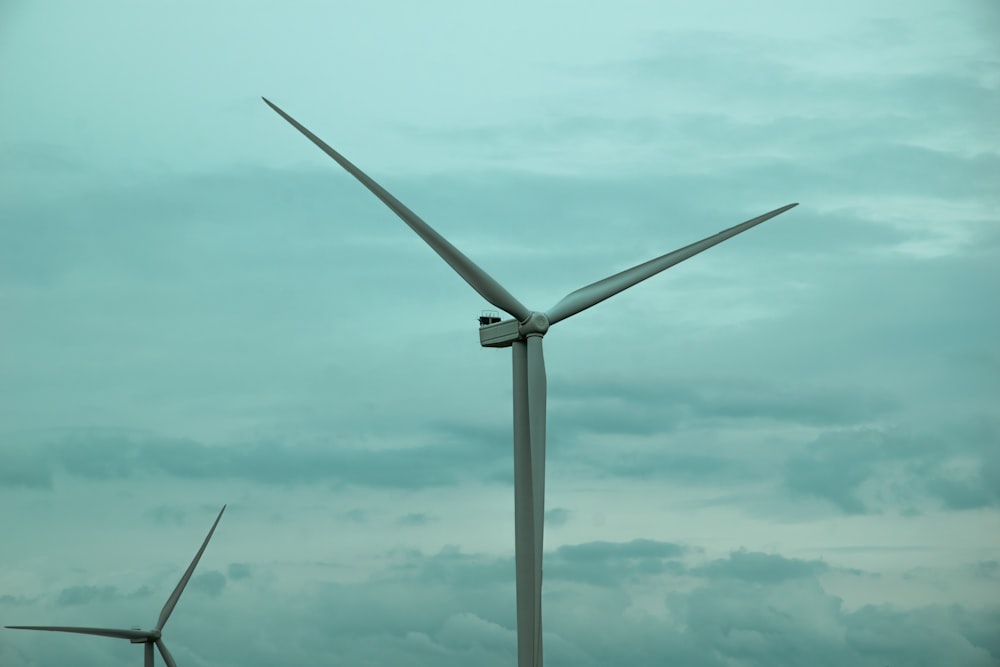 a wind farm with two windmills in the background