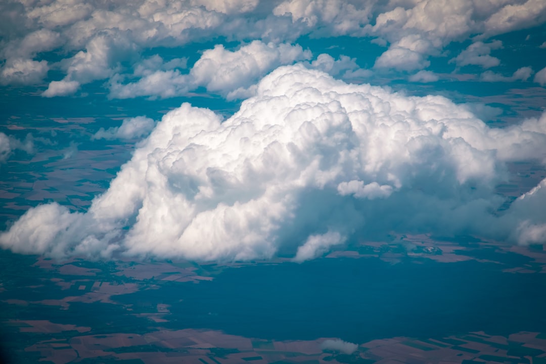 a large cloud is in the sky above the land,