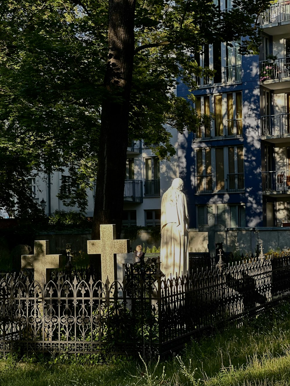 a cemetery in front of a building with a statue of a woman