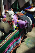 a llama stuffed animal sitting on top of a pile of blankets